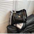 Detalle de bolso tote negro con cierre dorado y adorno de lazo de encaje blanco - Negro
