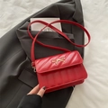Chic red quilted crossbody bag with golden bow ornament on elegant suit background - Red