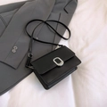 Bolso bandolera negro minimalista con hebilla plateada sobre un traje gris liso - Negro