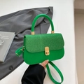 Green leather handbag with glitter patchwork and gold twist lock in a stylish setup - Green