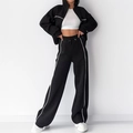 Women's black lounge set featuring a zip-up cropped jacket and white striped track pants - Black