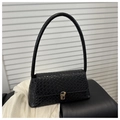 Close-up of black woven leather texture and golden metal clasp on a compact square bag - Black