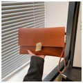 Detail of caramel envelope clutch bag featuring horizontal textures and gold buckle - Brown