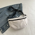 White crescent crossbody bag with black adjustable strap and fashion label on nylon - White