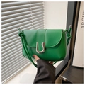 Detailed shot of green leather handbag featuring a silver U-shaped buckle and knotted strap - Green