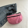 Pink crescent crossbody bag with adjustable black strap and fashion label detail - Fuchsia