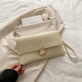 Elegante crèmekleurige enveloppe clutch met golftextuur en gouden gesp detail - Wit