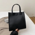 Minimalistische schwarze Tote Bag aus Glattleder mit eleganter Rundprägung - Schwarz