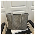 Detailed view of gray floral tote bag on black leather chair with decorative book - Gray