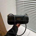 Sac bandoulière chic en cuir verni noir avec détails dorés sur fond de fenêtre minimaliste - Noir