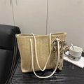 Bolso tote de paja tejida con diseño de espiga y pañuelo decorativo en mesa madera - Caqui
