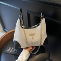 Détail du sac en toile avec garniture en cuir noir, chaîne dorée et pendentif cerf chic - Blanc et Noir