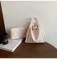 Detail of cream white litchi grain tote bag set with golden zipper on a wooden table - Off White