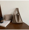 Close-up of khaki lychee grain leather tote bag set on wooden table with decor - Tan