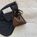 Sac seau marron à motif litchi avec pieds de protection dorés sur tissu blanc - Marron