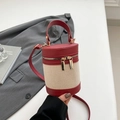 Red leather and beige canvas cylindrical bucket bag with dual zippers and crossbody strap - Red