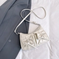 Chic cream white faux leather crossbody bag with decorative bows on a stylish suit background - White