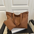 Brown faux leather tote bag set with small pouch on a black chair minimalist display - Brown