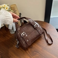Borsa bowling marrone vintage con doppi manici e tracolla su tavolo in legno - Marrone
