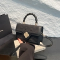 Elegant black crossbody bag with embossed texture and a golden floral lock buckle - Black