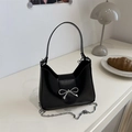 Bolso baguette minimalista de cuero negro con hebilla de lazo plateada y cadena fina - Negro