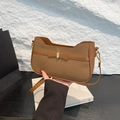 Braune Schultertasche mit Fischgrätenmuster und Schleife von einem Model gehalten - Braun