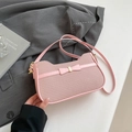 Light pink woven shoulder bag with a bow detail and golden metal hardware accent - Pink