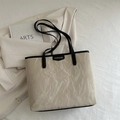 Bolso tote beige de diseño minimalista con textura plisada y correas negras finas - Caqui
