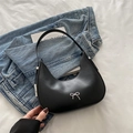 Elegant black crescent shoulder bag with silver bow accent on a casual denim backdrop - Black