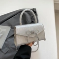 Elegante silberne Glitzer-Handtasche mit Strass-Schleife und Metall-Kettenriemen - Silber