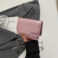 Détail de la texture crocodile rose brillant et de la chaîne en métal argenté - Rose