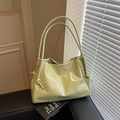 Minimalist mint green soft leather underarm tote bag on leather sofa with books - Green