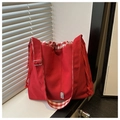 Detalle del bolso de mezclilla roja con cordón, textura de lona y forro de cuadros - Rojo