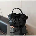 Detalle del bolso negro de cuero sintético plisado con lazo decorativo y asa curvada - Rosa