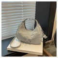 Close-up of silver pleated handbag with metal bow detail and natural wrinkled texture - Silver