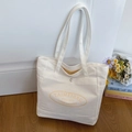 Minimalist cream canvas tote bag with yellow branding and long handles on wooden floor - Off White