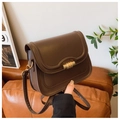 Close-up of vintage dark brown crossbody bag with gold cylindrical metal twist lock - Coffee