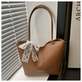 Détail d'un sac cabas marron en cuir avec un nœud en dentelle blanche et logo - Marron