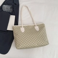 Khaki monogram tote tas met witte handvatten en M-patroon op een minimalistisch bureau - Wit