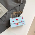 Light blue square crossbody bag with red cherry prints and golden chain strap - Blue