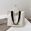 Borsa tote minimalista in tela crema con scritte nere e tracolle a contrasto - Bianco