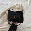Retro black crocodile embossed shoulder bag with vintage gold clasp on a beige blazer - Black