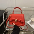 Fashionable red top-handle handbag with gold ring lock and adjustable strap - Red