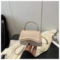 Dettaglio della borsa color crema con patta ondulata asimmetrica dal design unico - Cachi