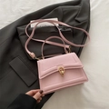 Pink PU leather handbag with gold buckle and adjustable strap on grey blazer - Pink