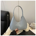 Close-up of light blue patent leather hobo bag with high-gloss finish and sleek shoulder strap - Blue