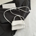 Minimalist white PU leather crossbody bag with flap cover on a dark background - White