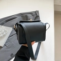 Chic black pebbled leather crossbody bag with elegant gold buckle and adjustable strap - Black
