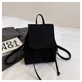 Primer plano de mini mochila negra con textura arrugada y cierre de solapa minimalista - Negro