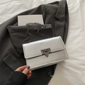 Silver metallic rectangular crossbody chain bag with dark metal buckle on a grey suit - Silver